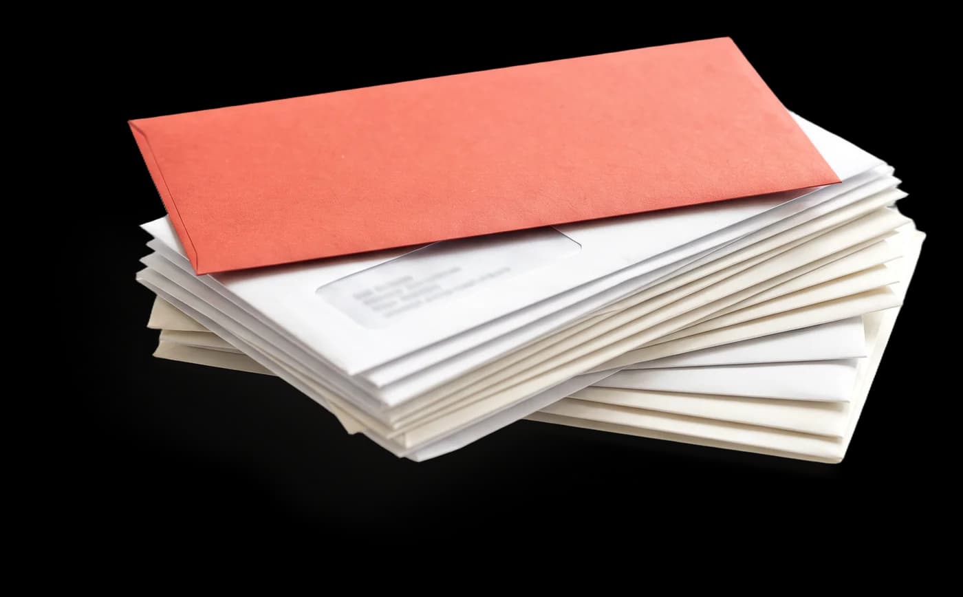 Stack of white window envelopes with a red envelope on top